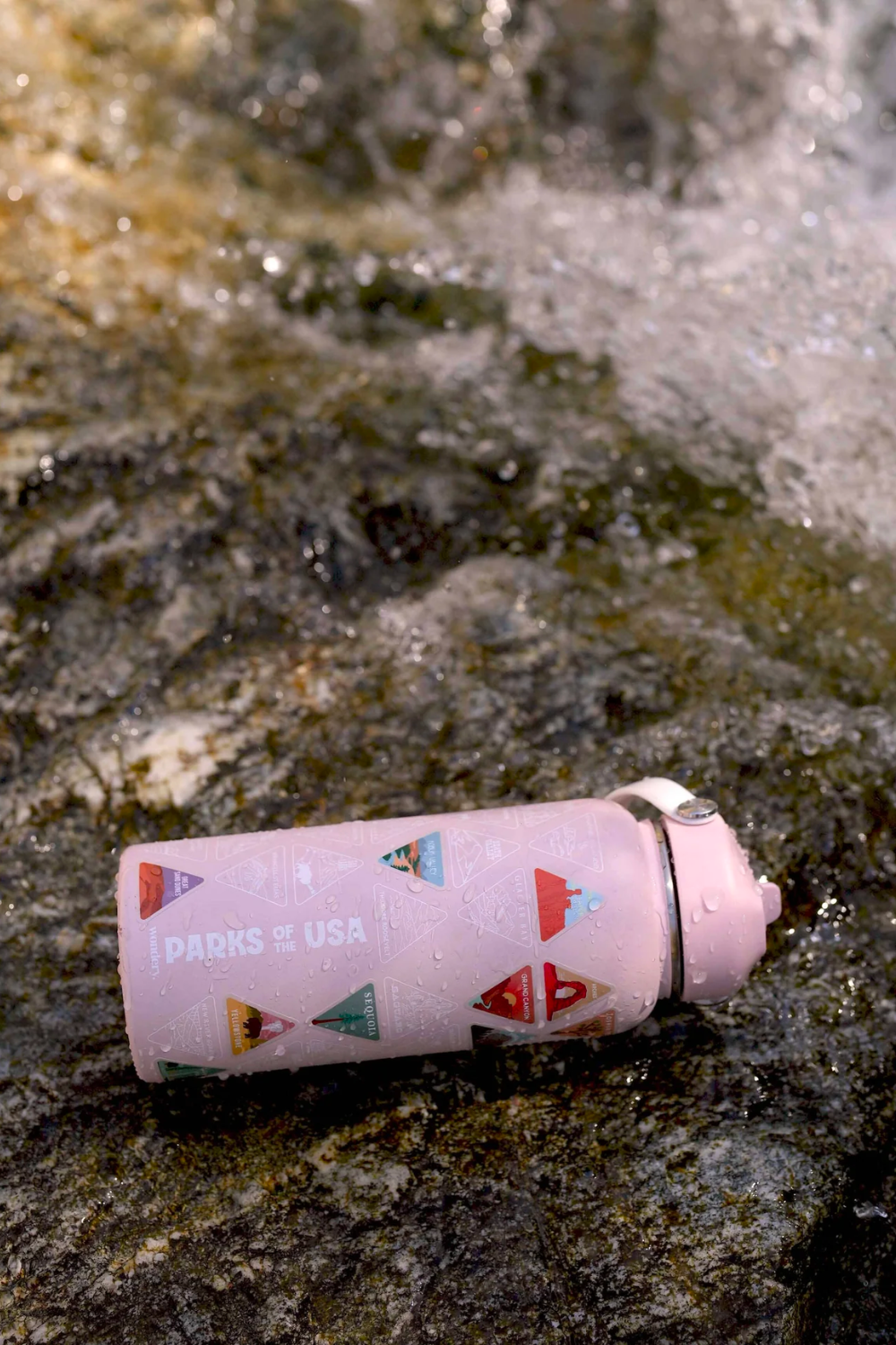 #color_dusty pink _pink travel camping hiking water bottle with carrying strap on river trail