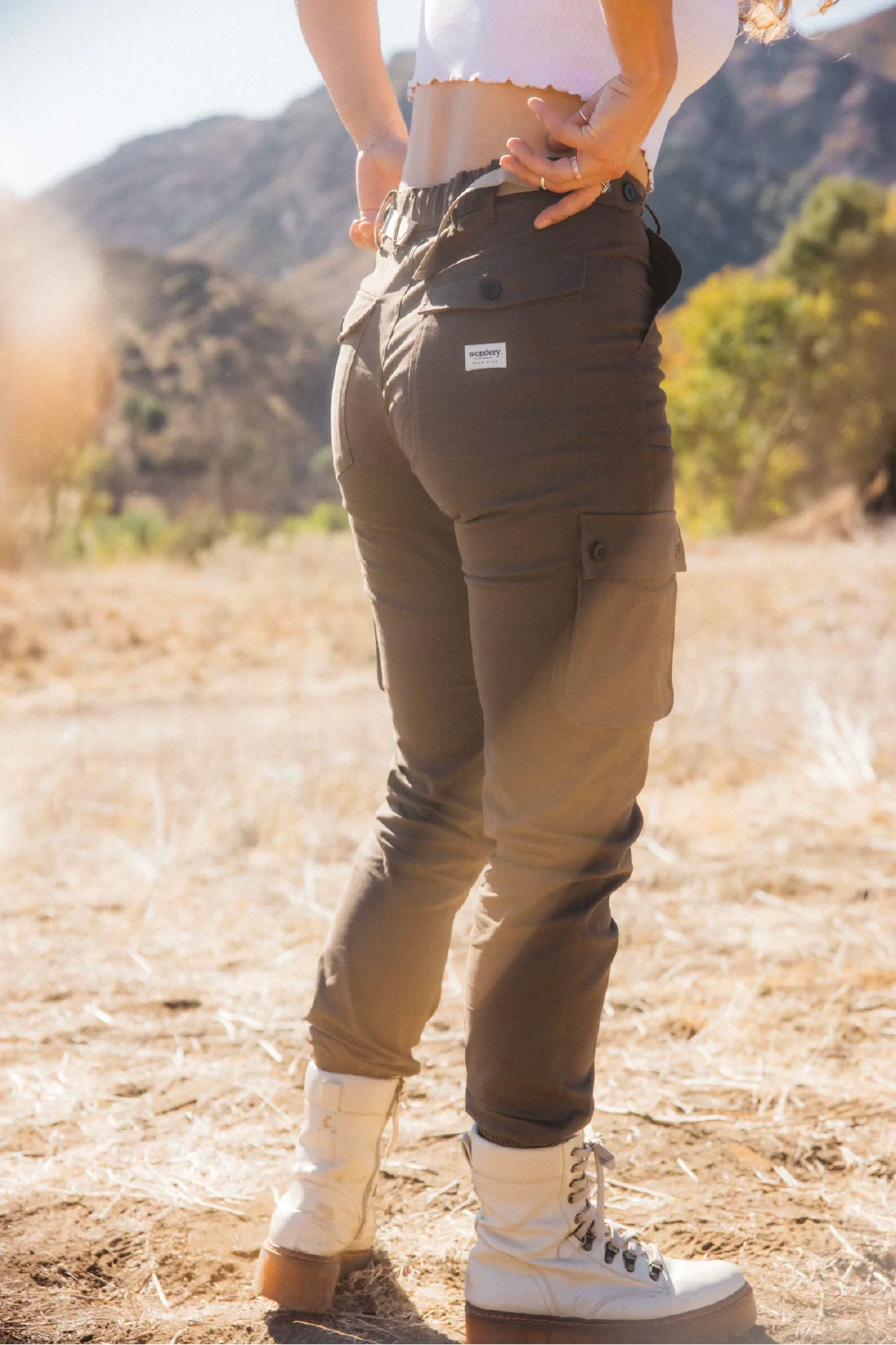 woman in khaki brown cargo outdoor hiking camping pants and crop tank top #color_brew