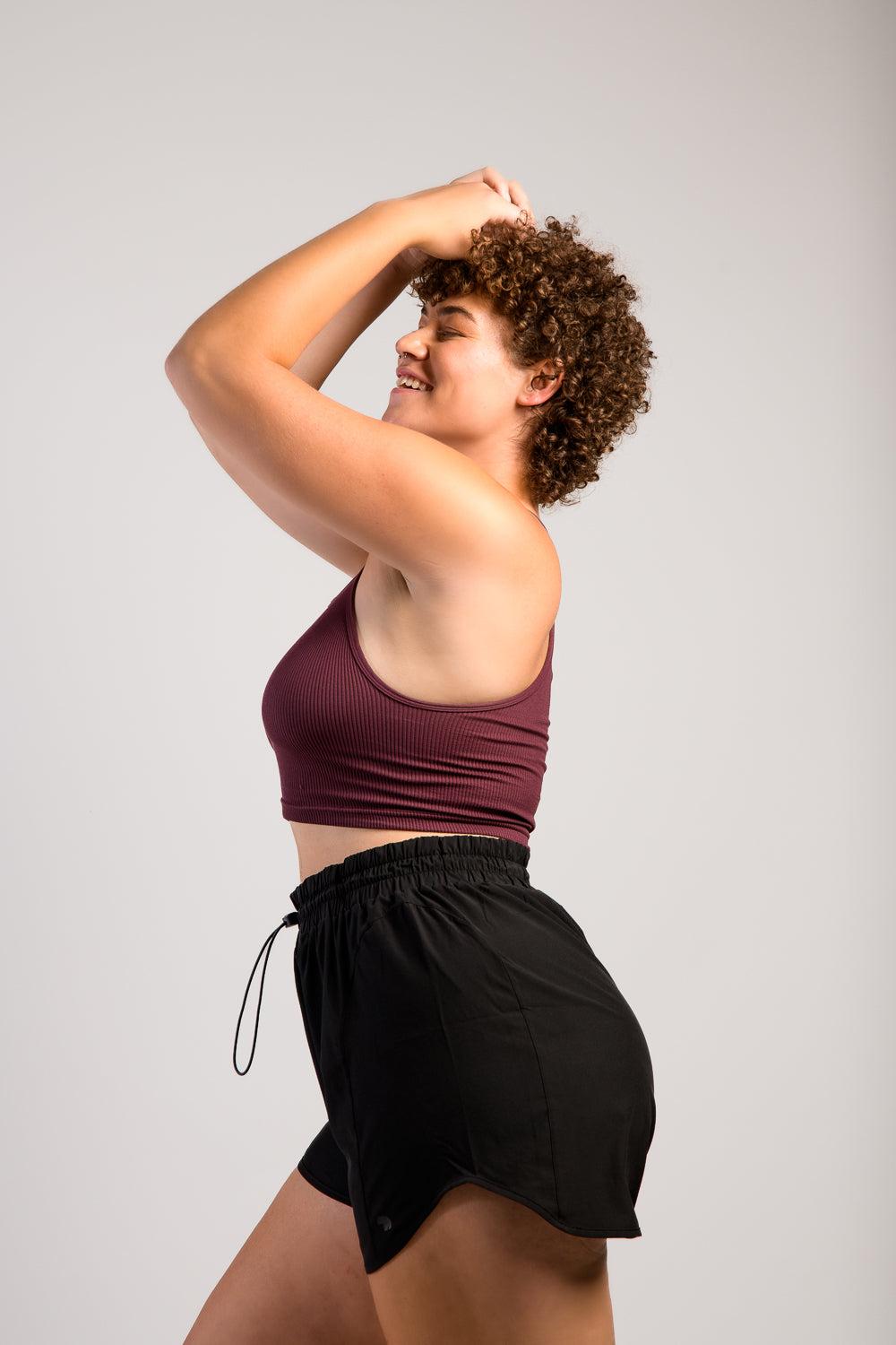 tall woman in black workout running track shorts with tank top #color_black