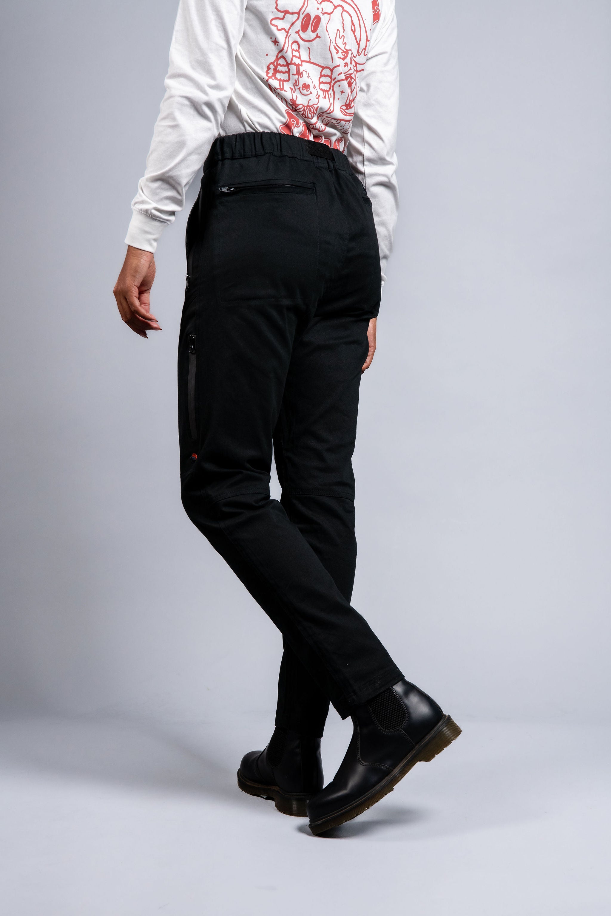 woman in adjustable black hiking pants and long sleeve top #color_black