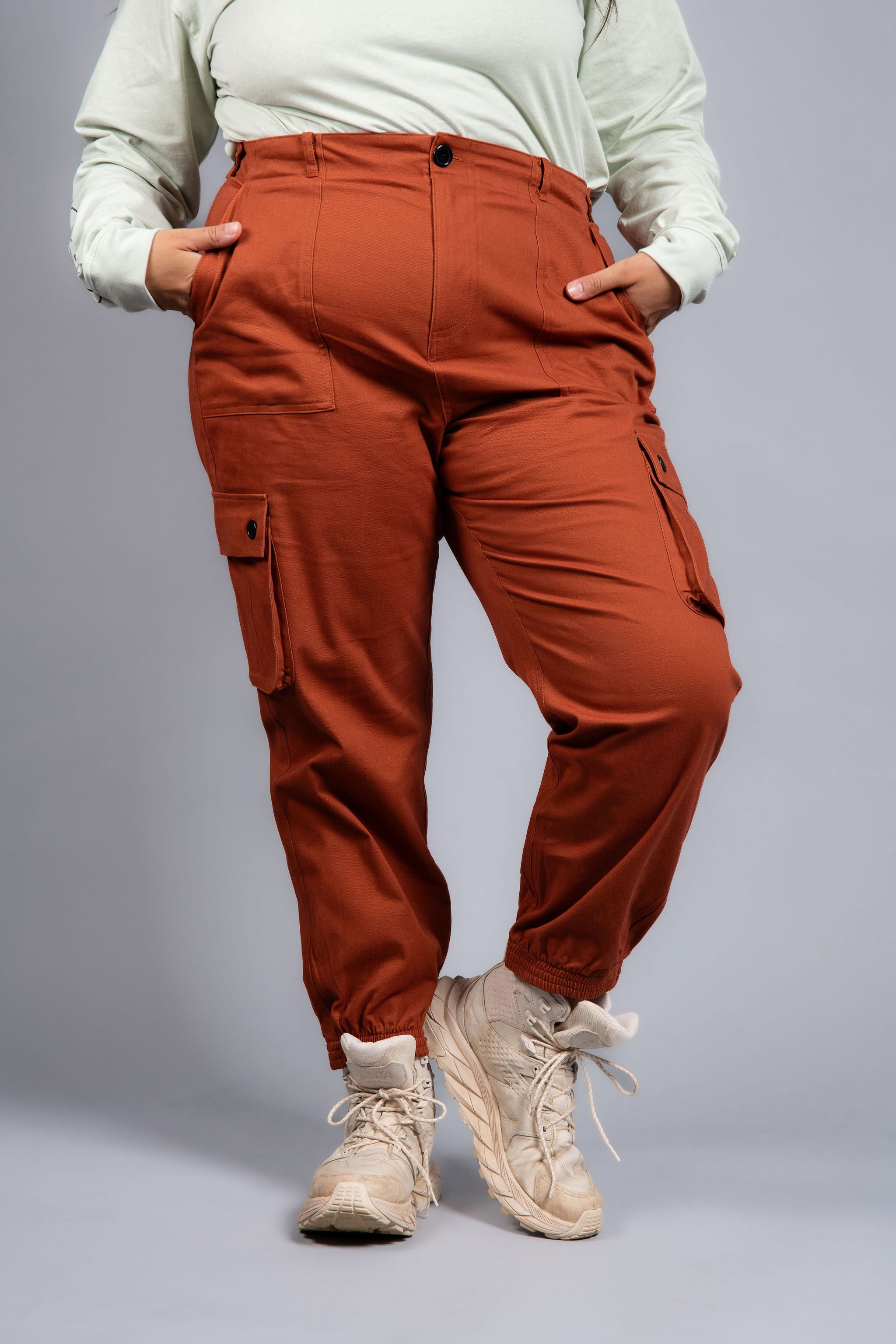 woman in adjustable orange cargo hiking pants and long sleeve top #color_burnt Sienna