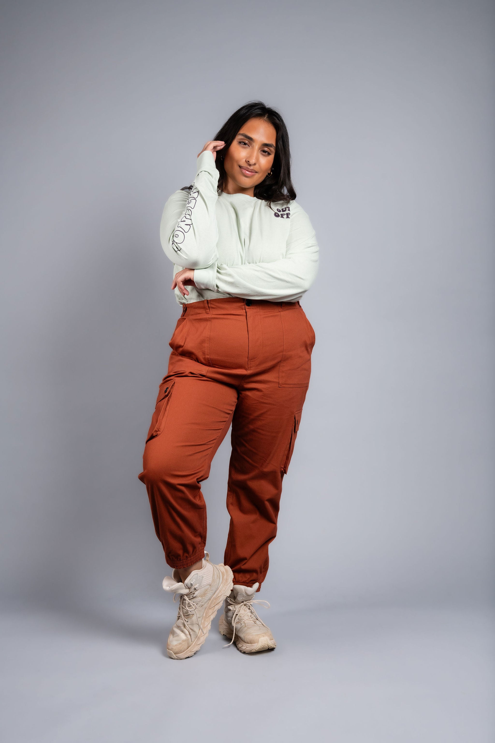 woman in adjustable orange cargo hiking pants and long sleeve top #color_burnt Sienna