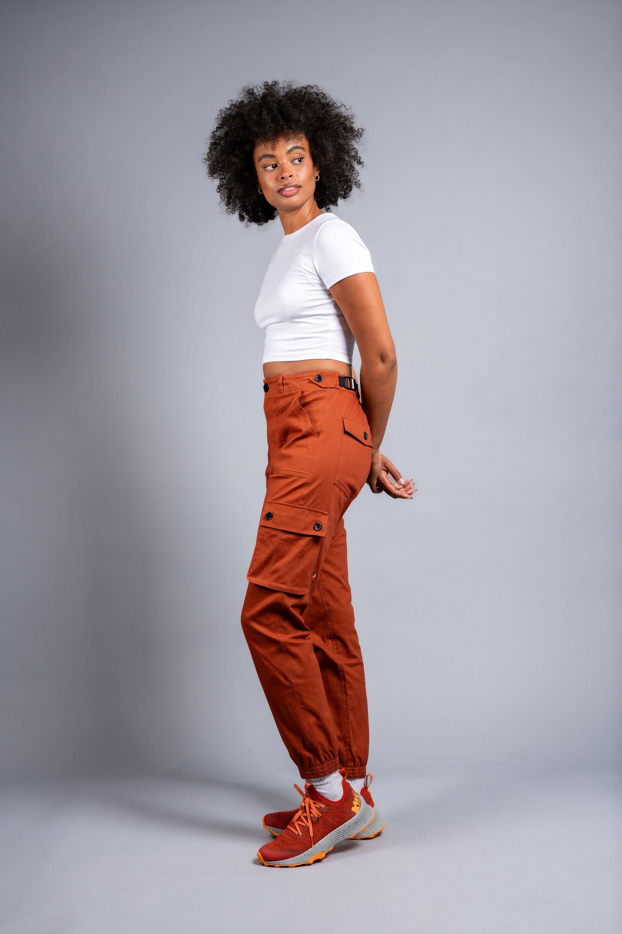 woman in adjustable orange cargo hiking pants and tee shirt #color_burnt Sienna