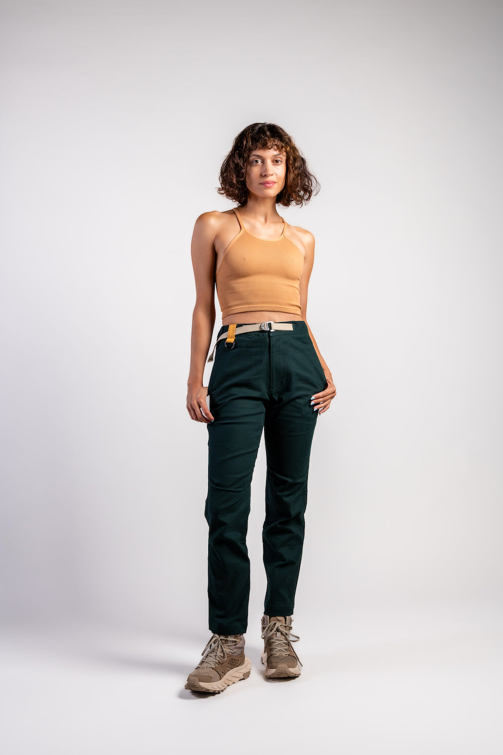 Woman with bob cut short hair in casual straight leg pants and orange tank top #color_emerald