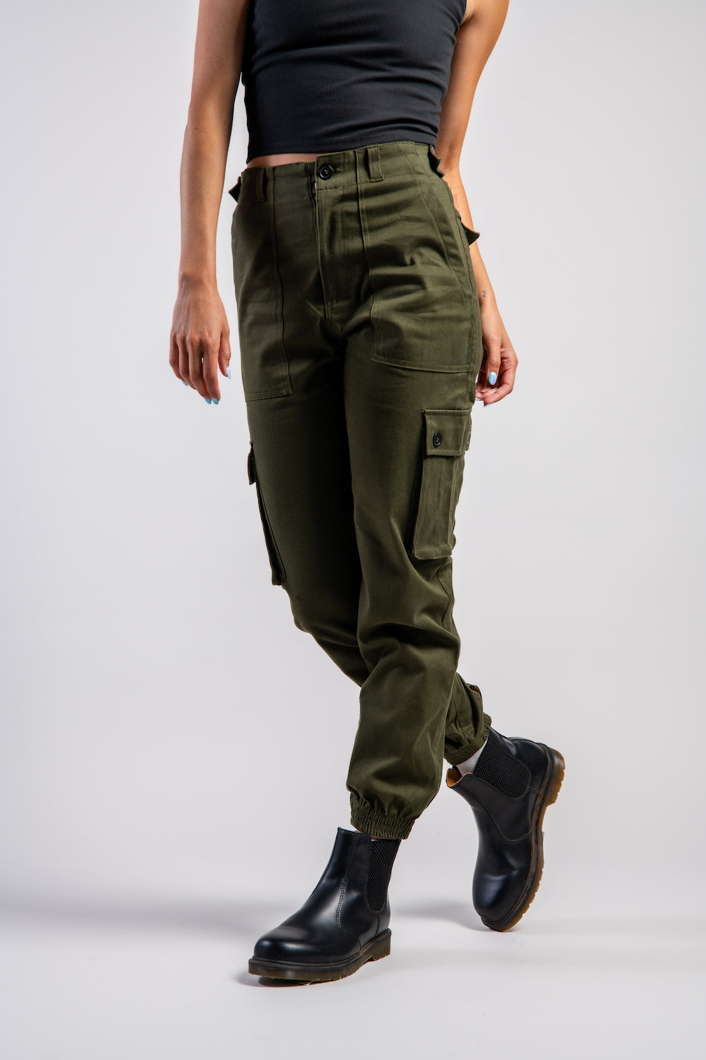 woman in army green cargo outdoor hiking camping pants and asymmetrical black top #color_forest