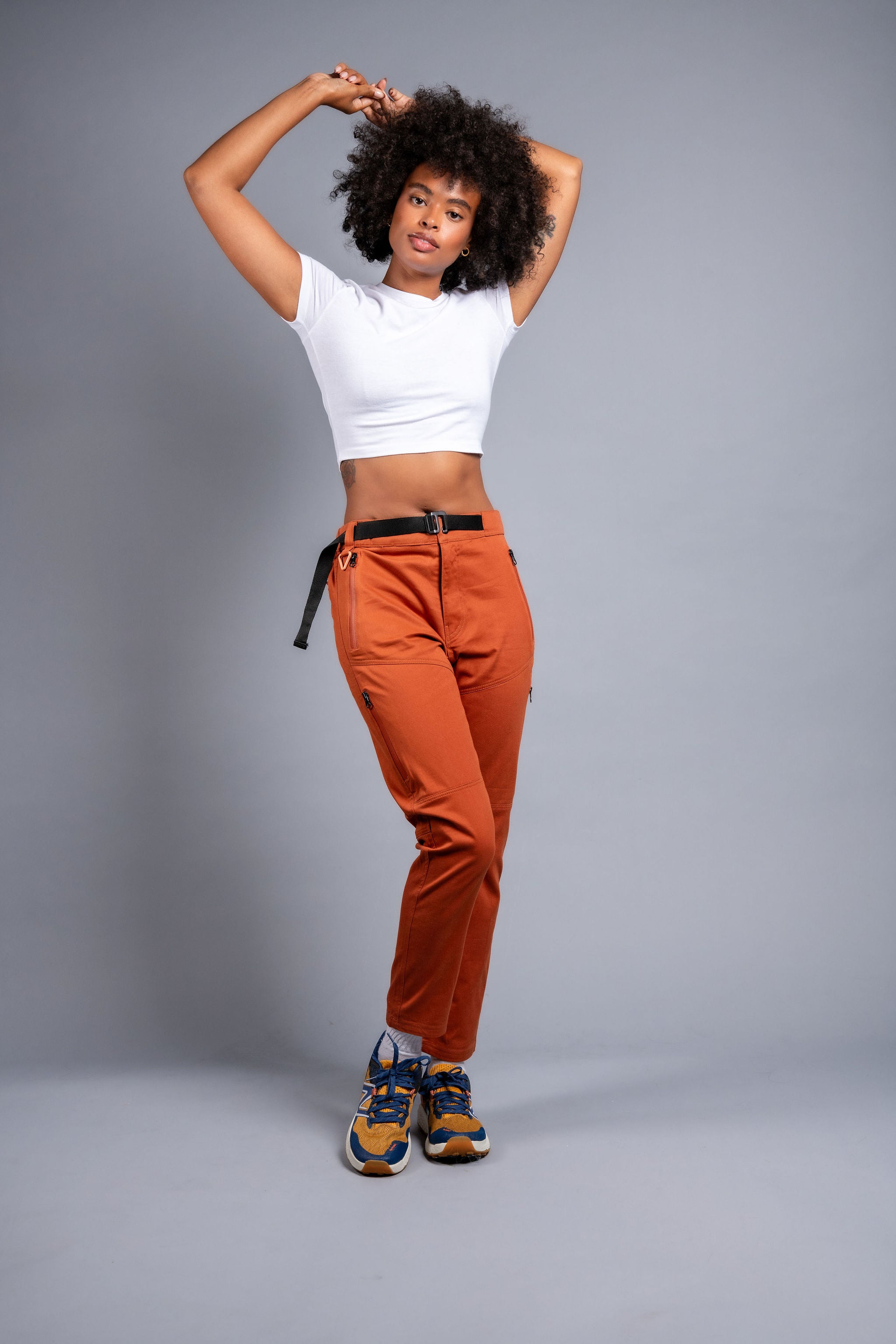 woman in adjustable orange hiking pants and tee shirt #color_red rocks