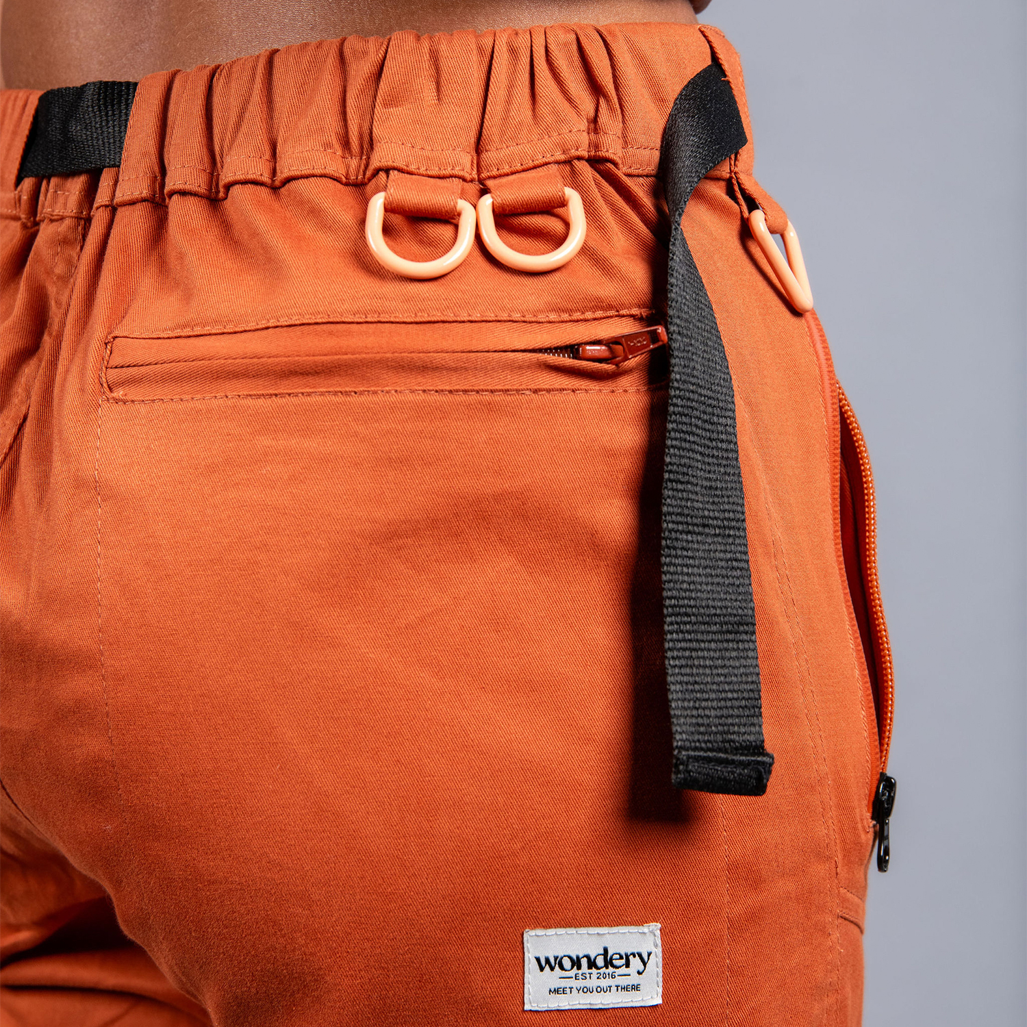 woman in adjustable orange hiking pants and tee shirt #color_red rocks