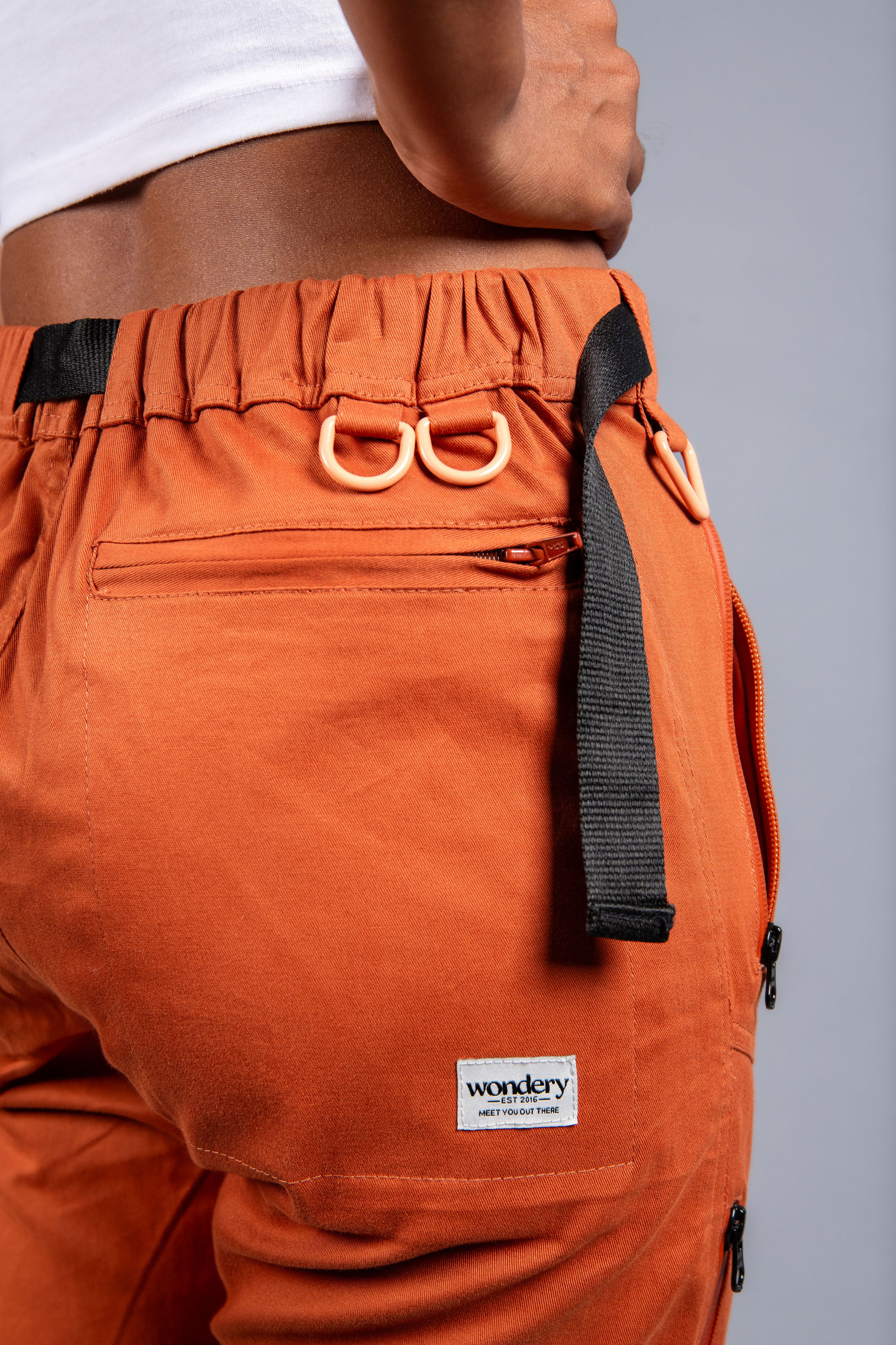 woman in adjustable orange hiking pants and tee shirt #color_red rocks