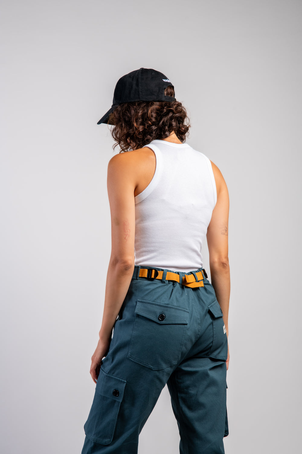 woman in adjustable blue cargo hiking pants and tank top #color_teal