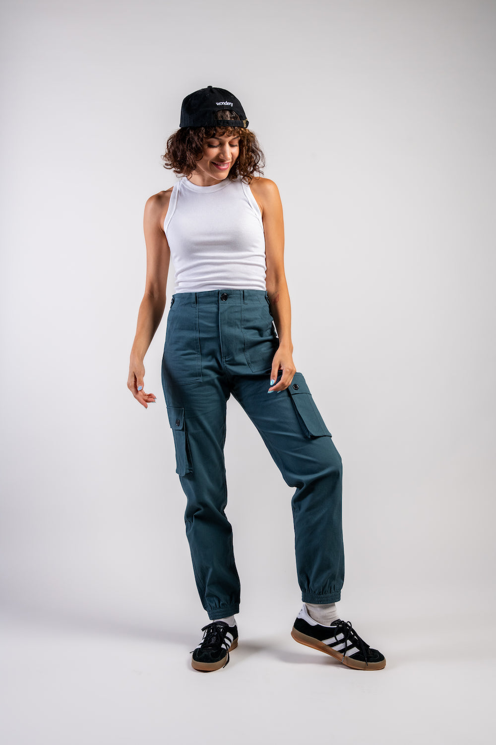 woman in adjustable blue cargo hiking pants and tank top #color_teal