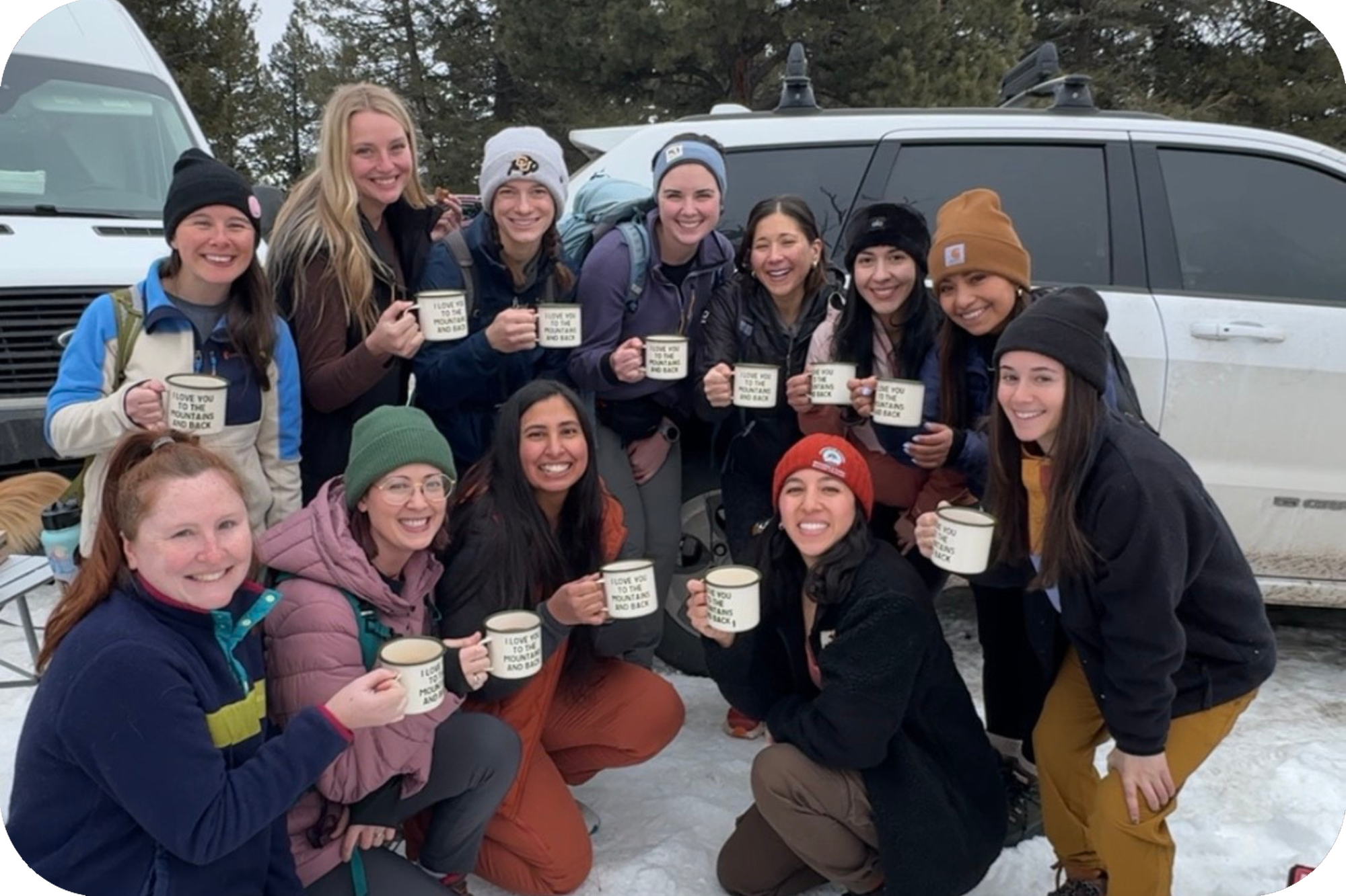 Group of women hiking with hot chocolate in matching mugs