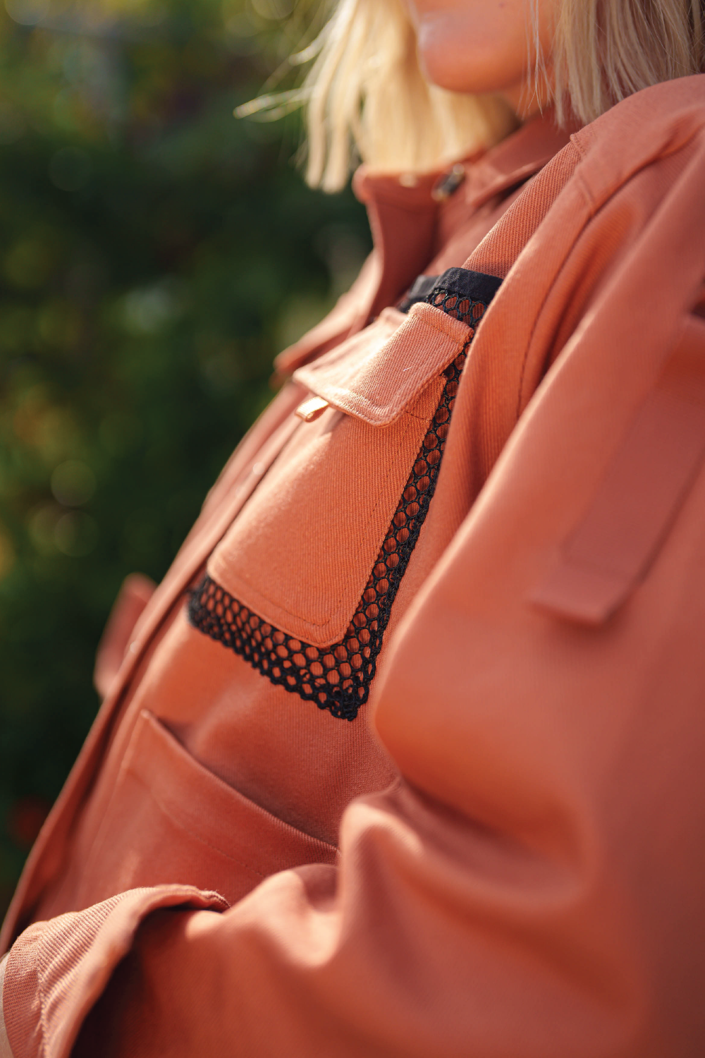 detail close image of red coral denim jacket front cargo pocket with black mesh pocket accent