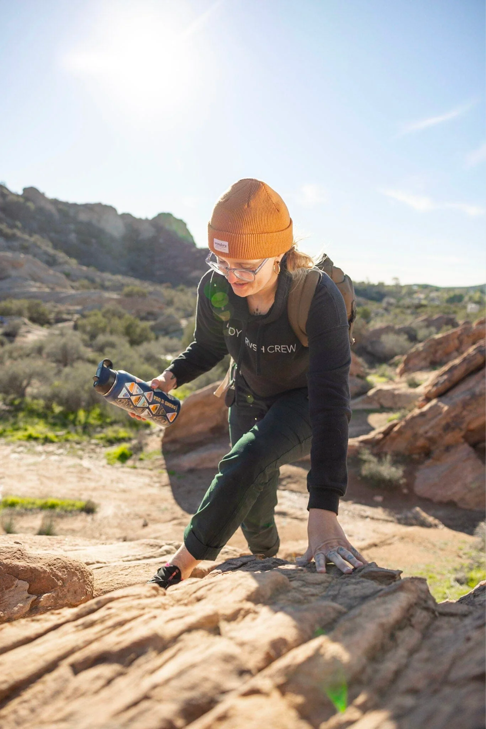 woman hiking rocky mountains with blue travel camping hiking water bottle #color_ocean