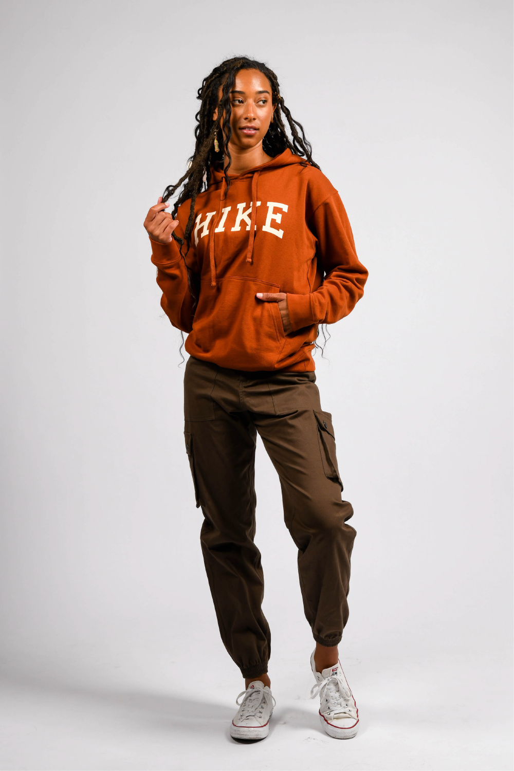 petite black woman in orange pullover outdoor hoodie with pockets #color_rust brown
