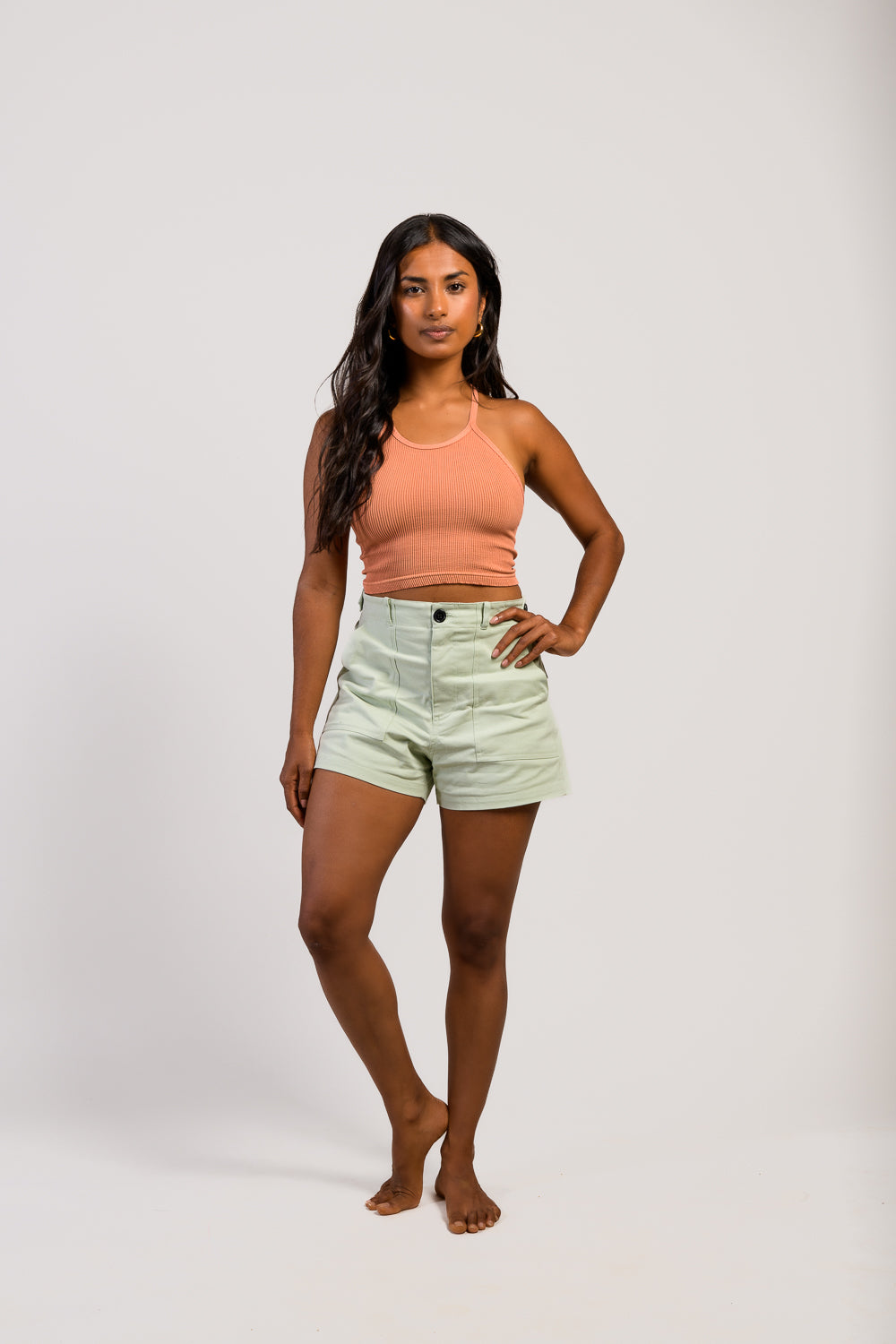 petite woman in adjustable green cargo hiking shorts and pink tank top #color_agave