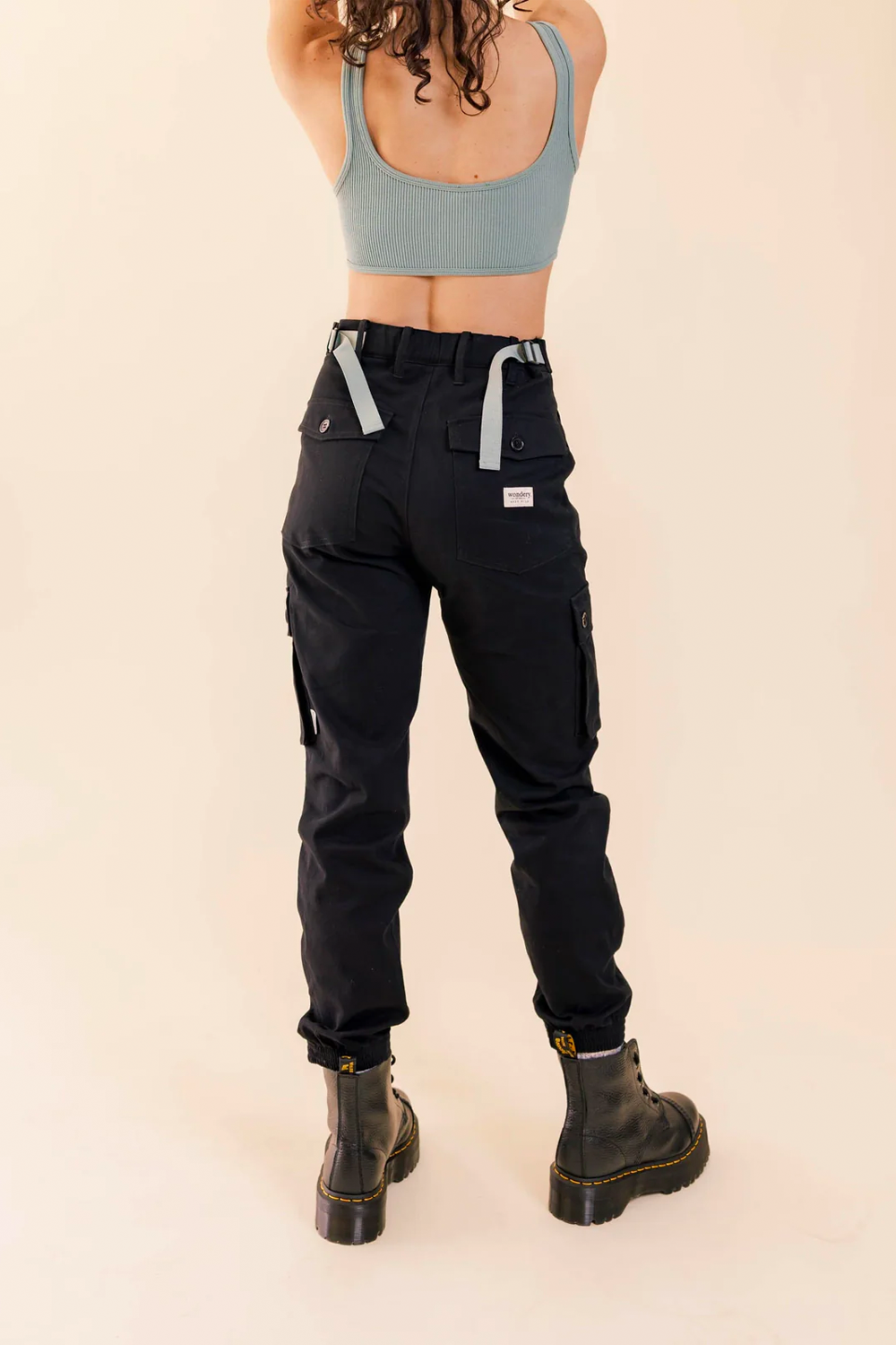 woman in black cargo outdoor hiking camping pants and crop tank top and dr. martens #color_black