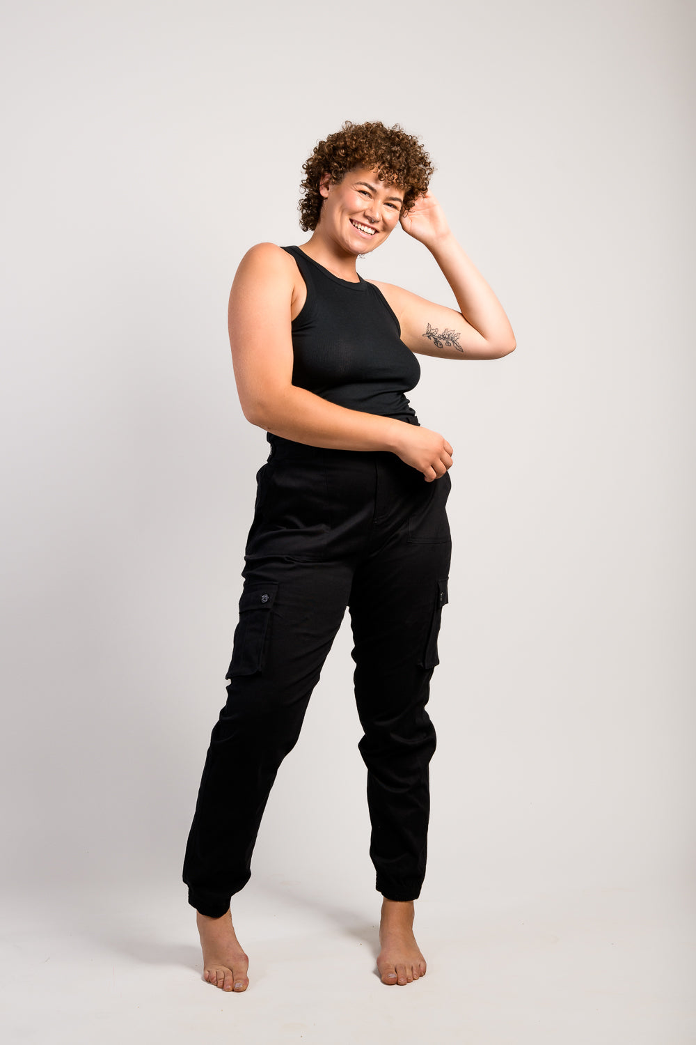 tall plus size woman in adjustable black cargo hiking pants and tank top #color_black