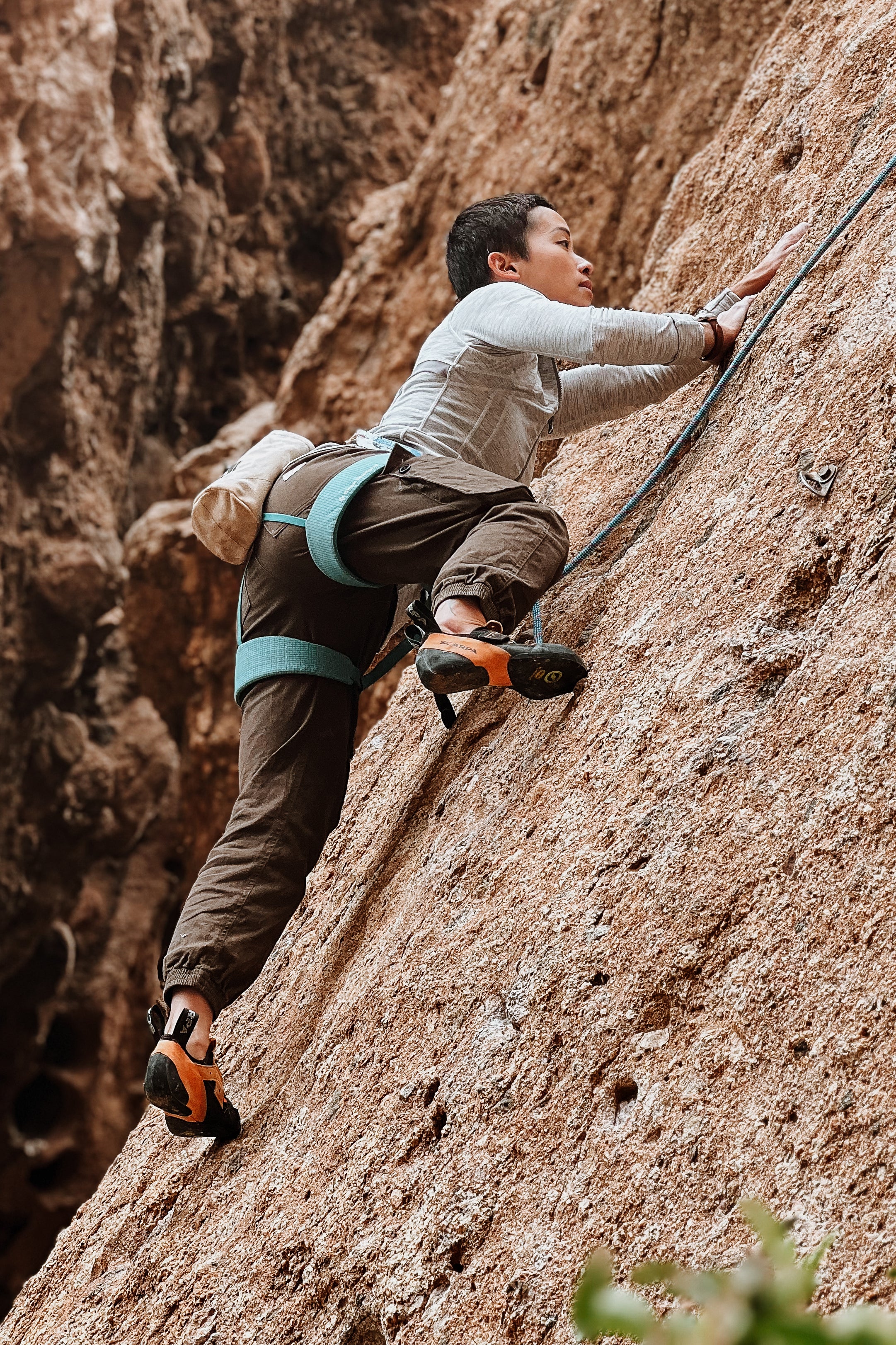 woman climbing in adjustable waist outdoor hiking pants with cargo pockets #color_brew