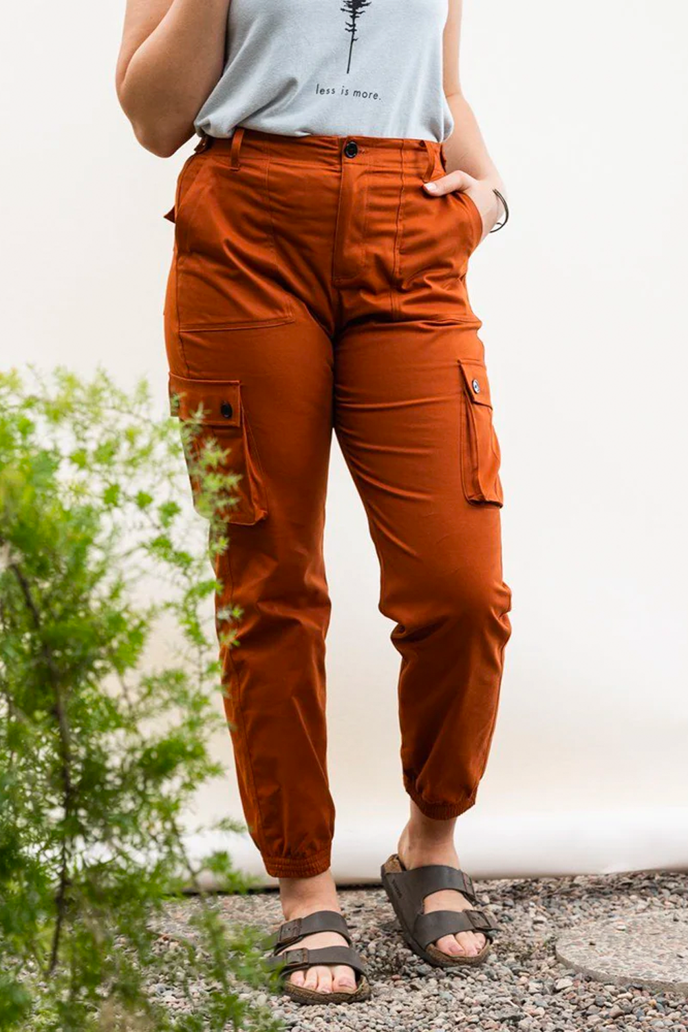 BIPOC woman in orange brown cargo outdoor hiking camping pants and tank top #color_burnt sienna