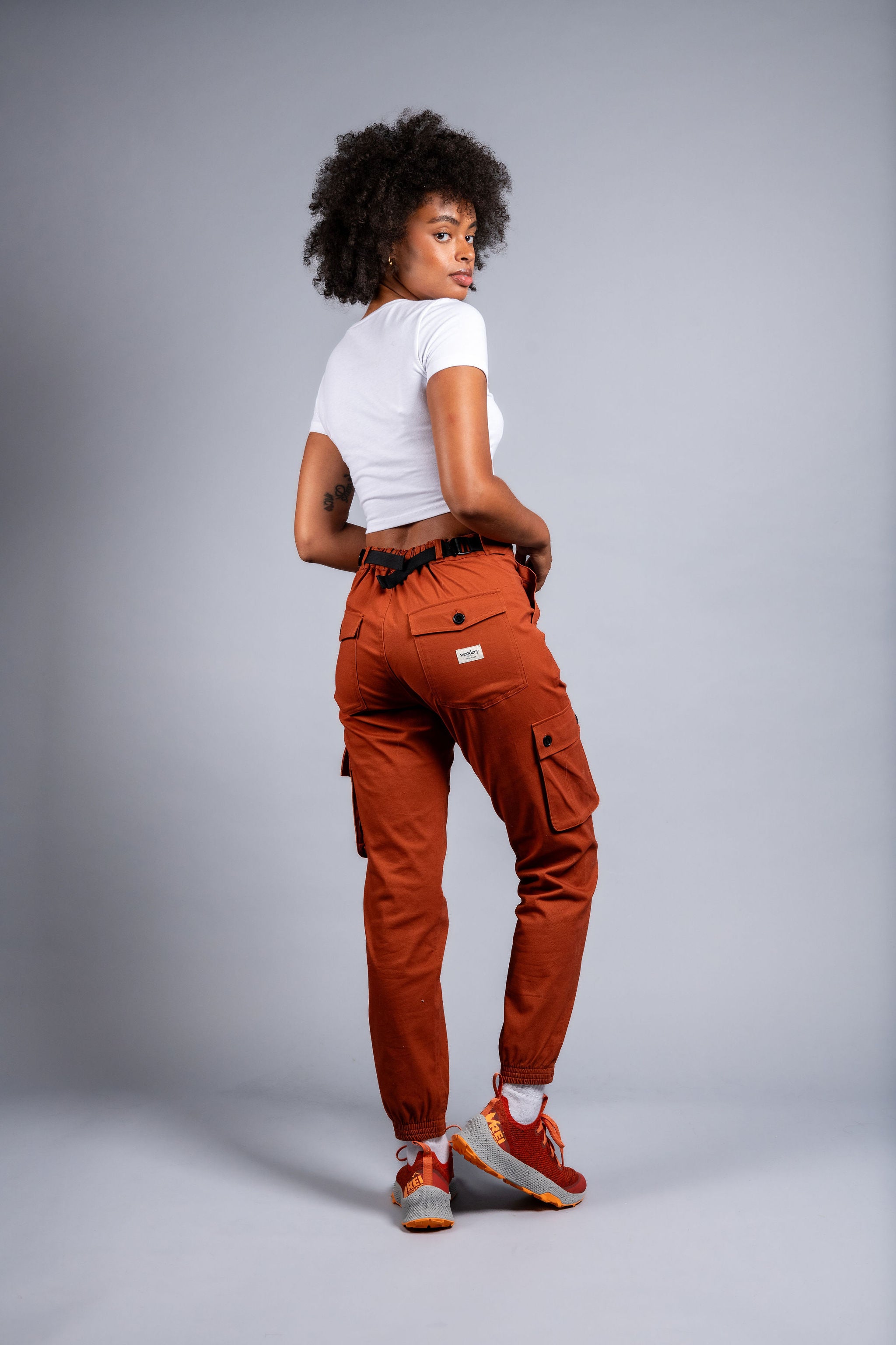 woman in adjustable orange cargo hiking pants and tee shirt #color_burnt Sienna