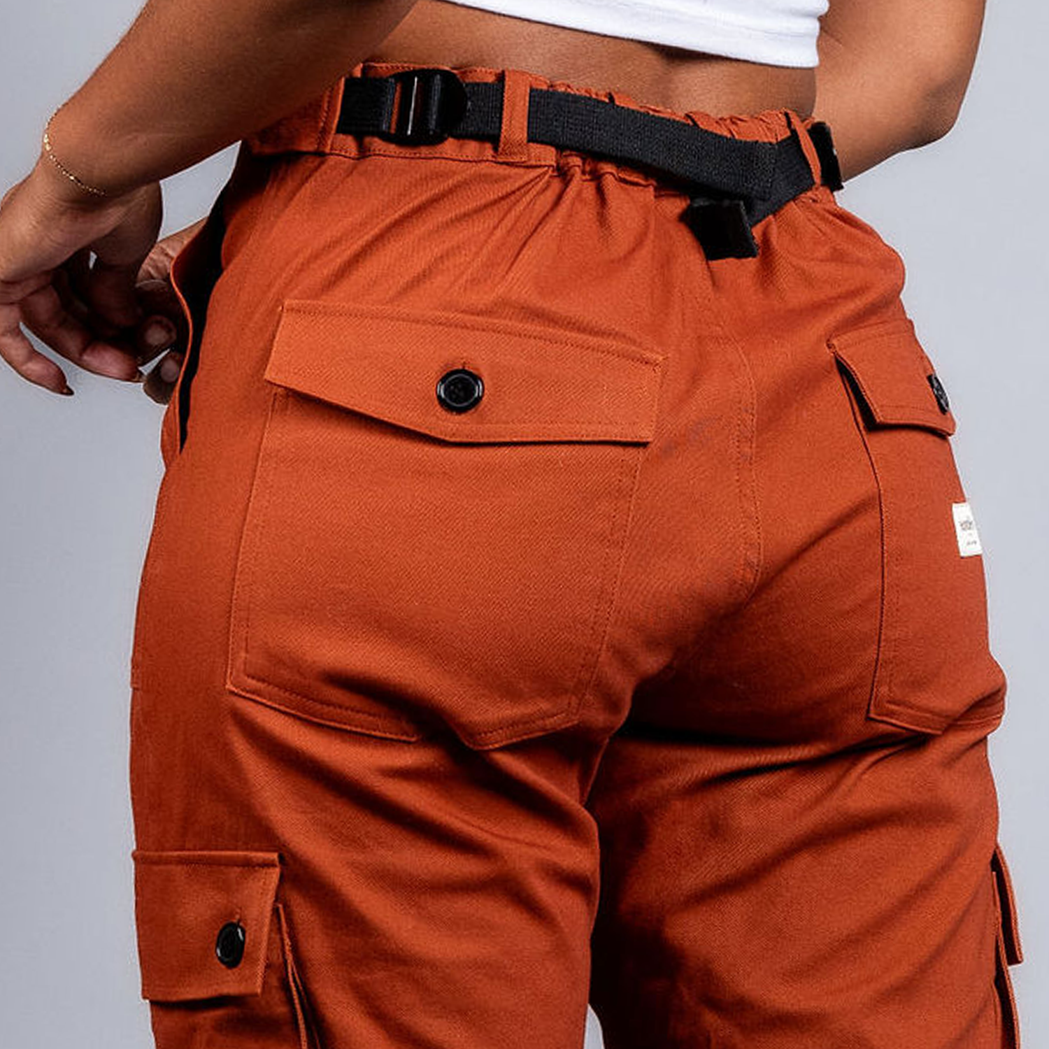 woman in adjustable orange cargo hiking pants #color_burnt Sienna