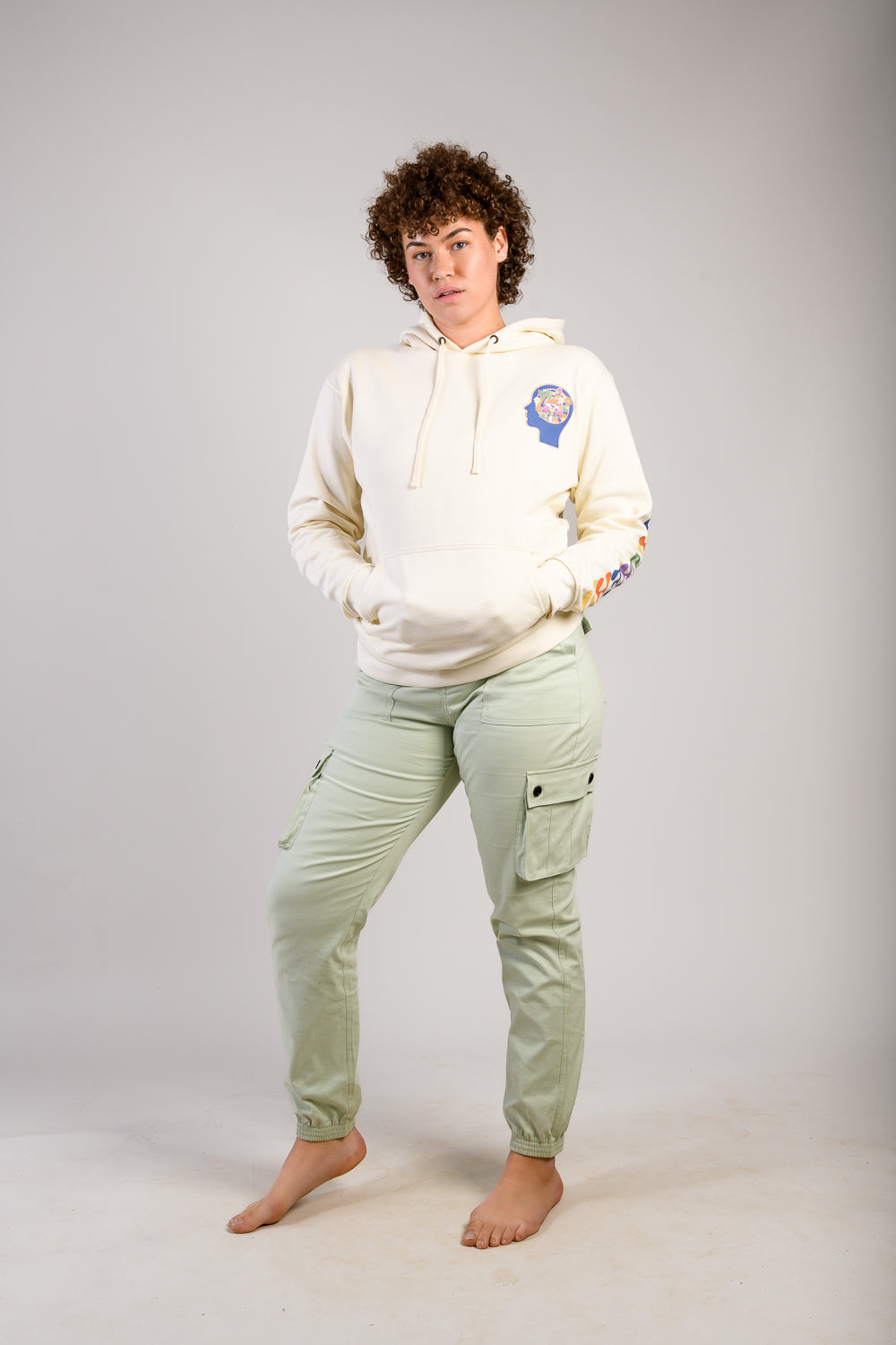 Woman with curly hair cargo pants and cream long sleeve hoodie #color_dove