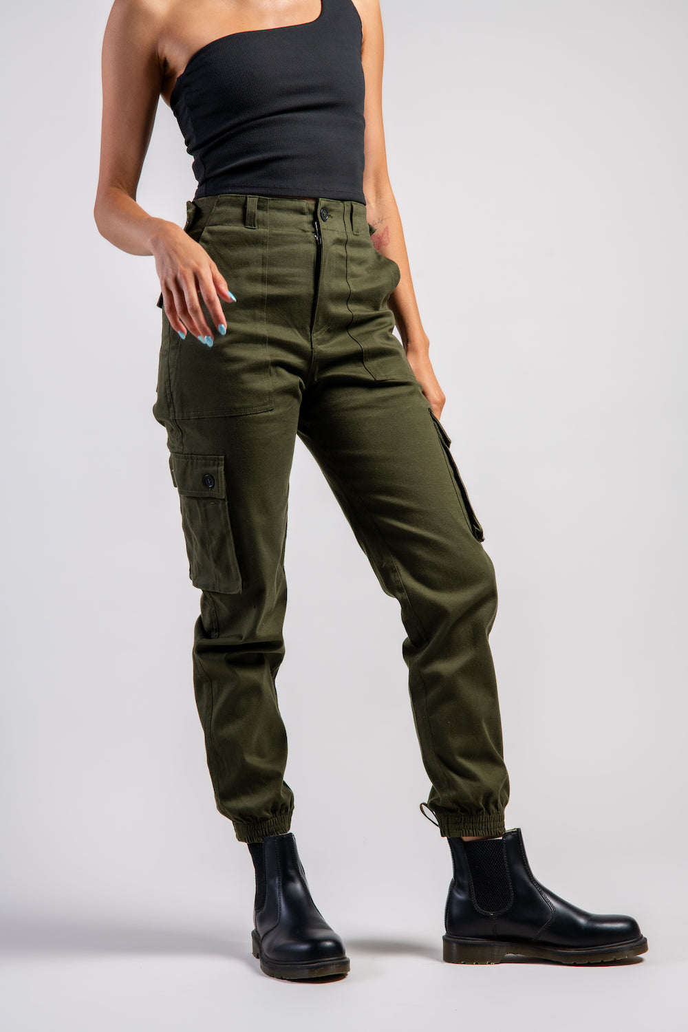 woman in army green cargo outdoor hiking camping pants and asymmetrical black top #color_forest