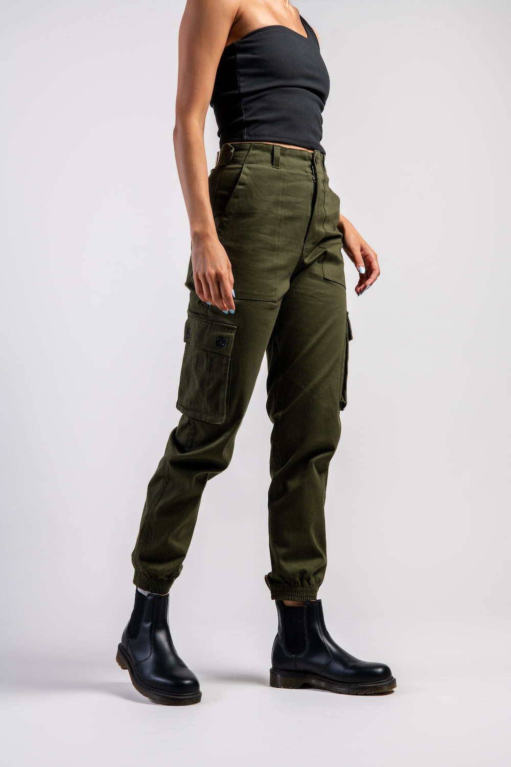 woman in army green cargo outdoor hiking camping pants and asymmetrical black top #color_forest