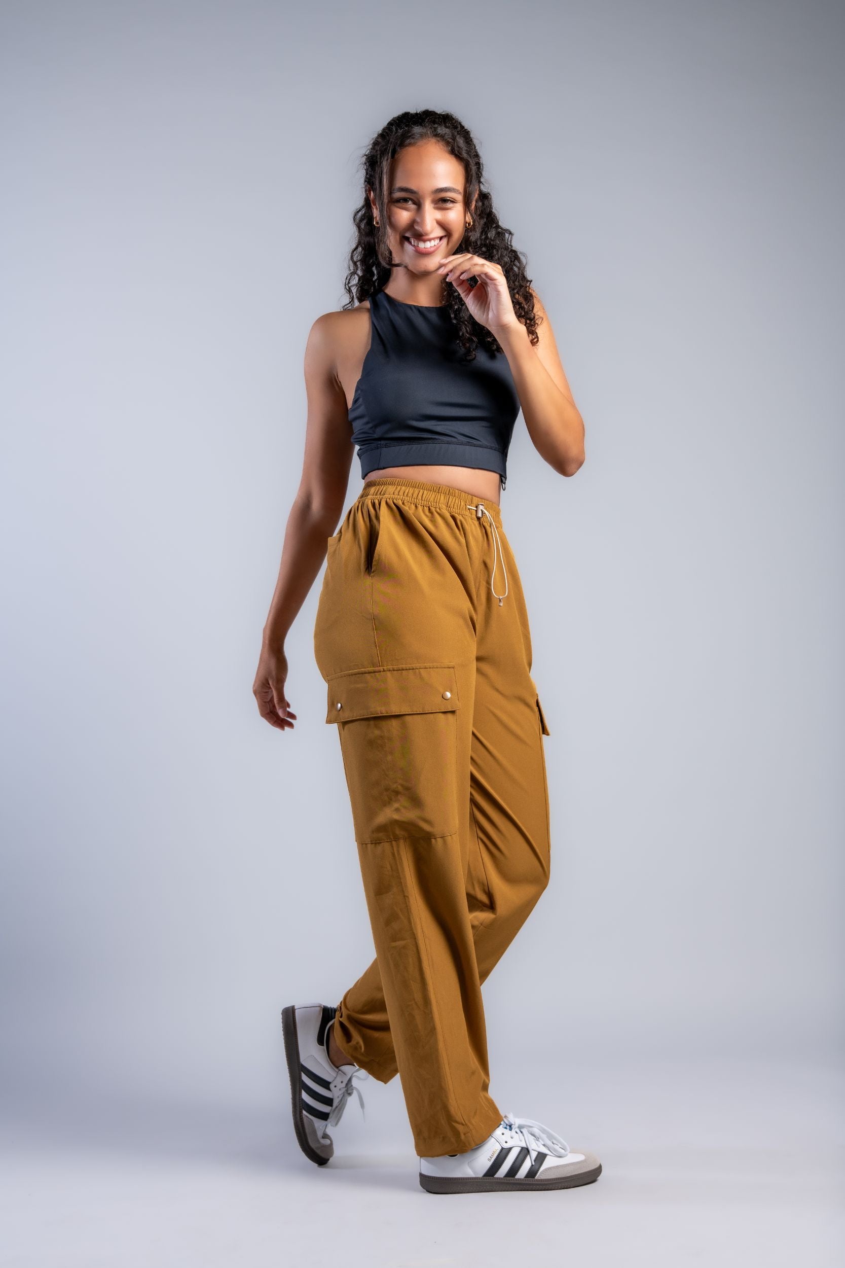 brown woman in black tank top and brown loose lounge pants #color_ochre