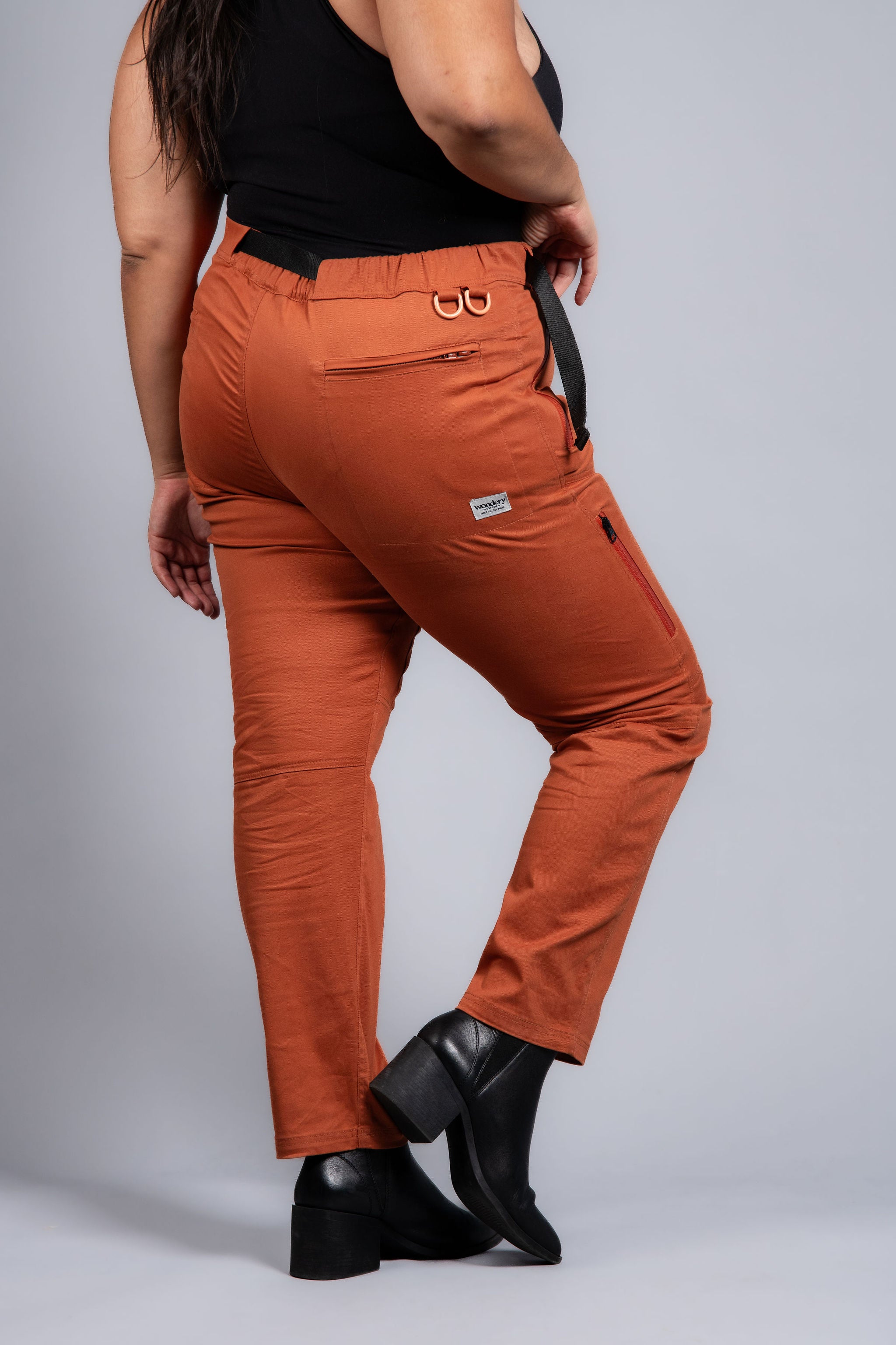 woman in adjustable orange hiking pants and tank top #color_red rocks