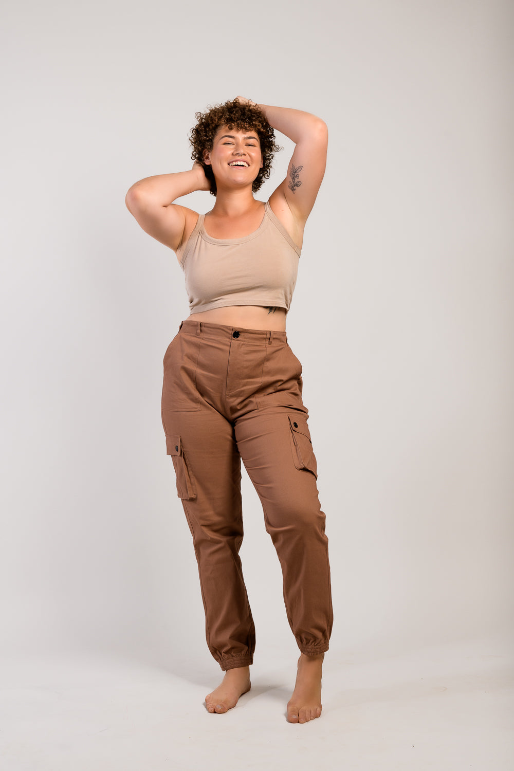 Tall plus size woman in adjustable brown cargo hiking pants and tank top #color_umber