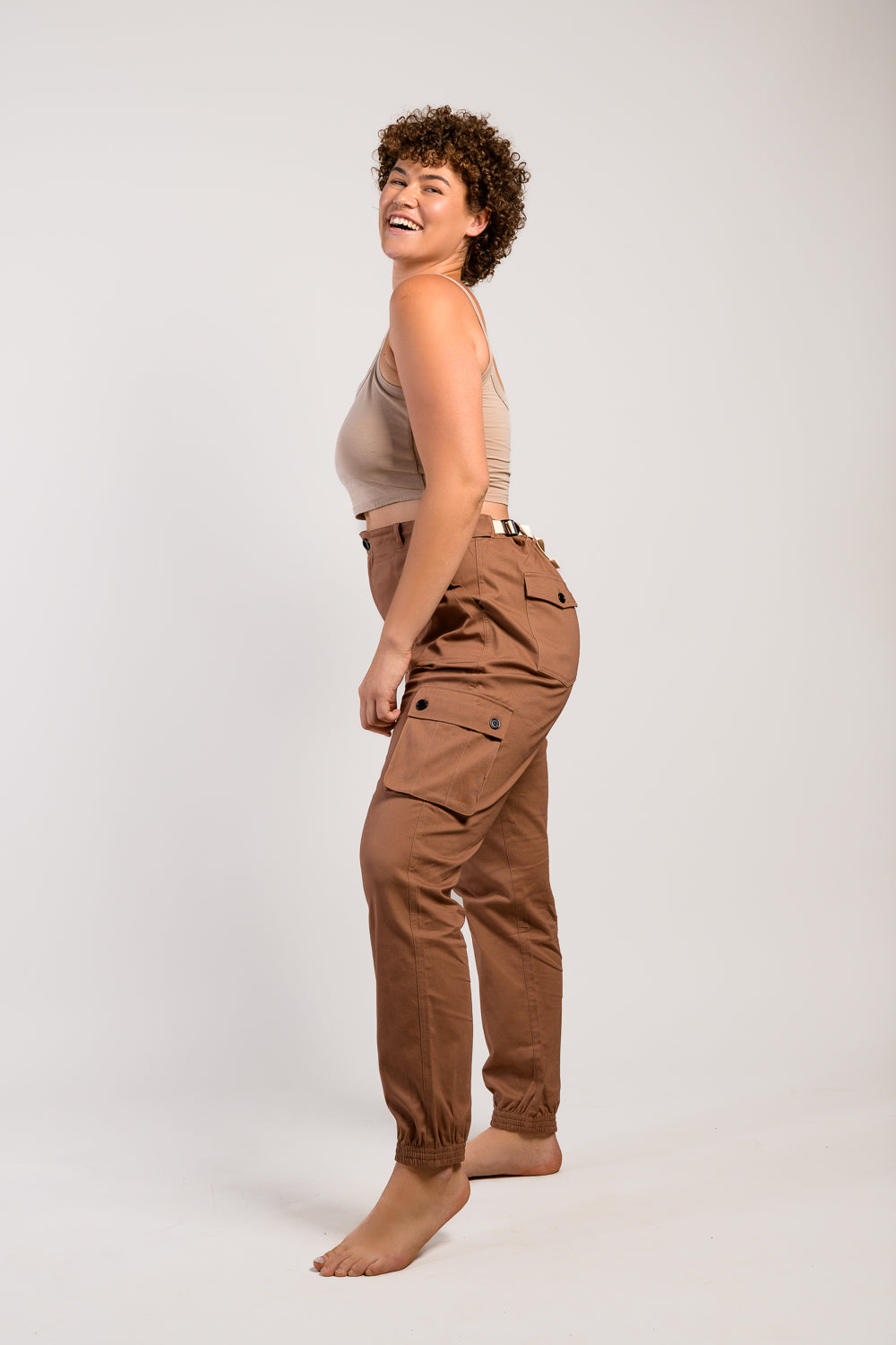 Tall plus size woman in adjustable brown cargo hiking pants and tank top #color_umber