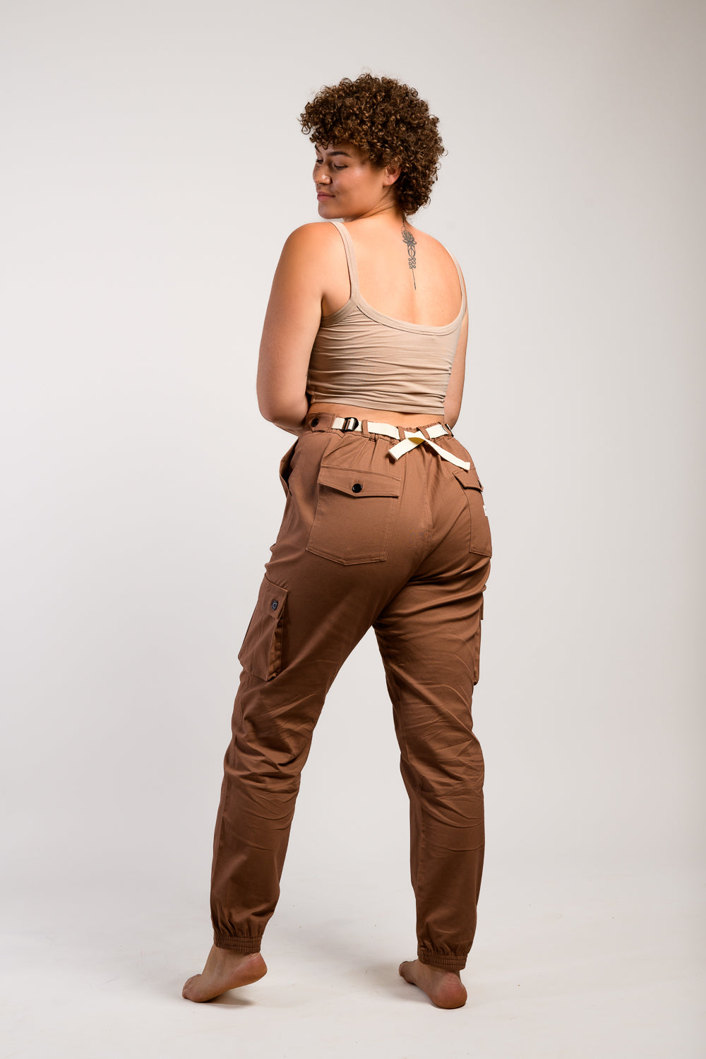 Tall plus size woman in adjustable brown cargo hiking pants and tank top #color_umber