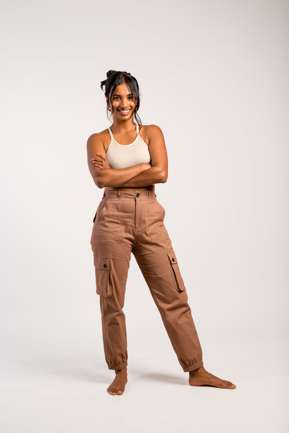 petite woman in adjustable brown cargo hiking pants and tank top #color_umber